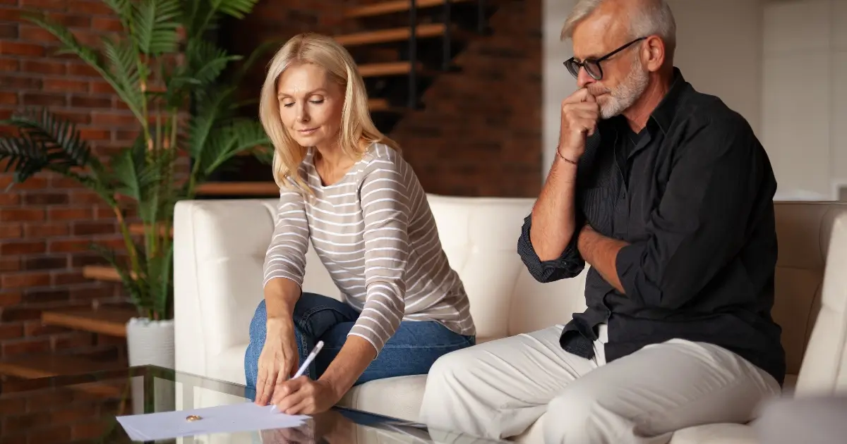 older, wealthy couple signing papers