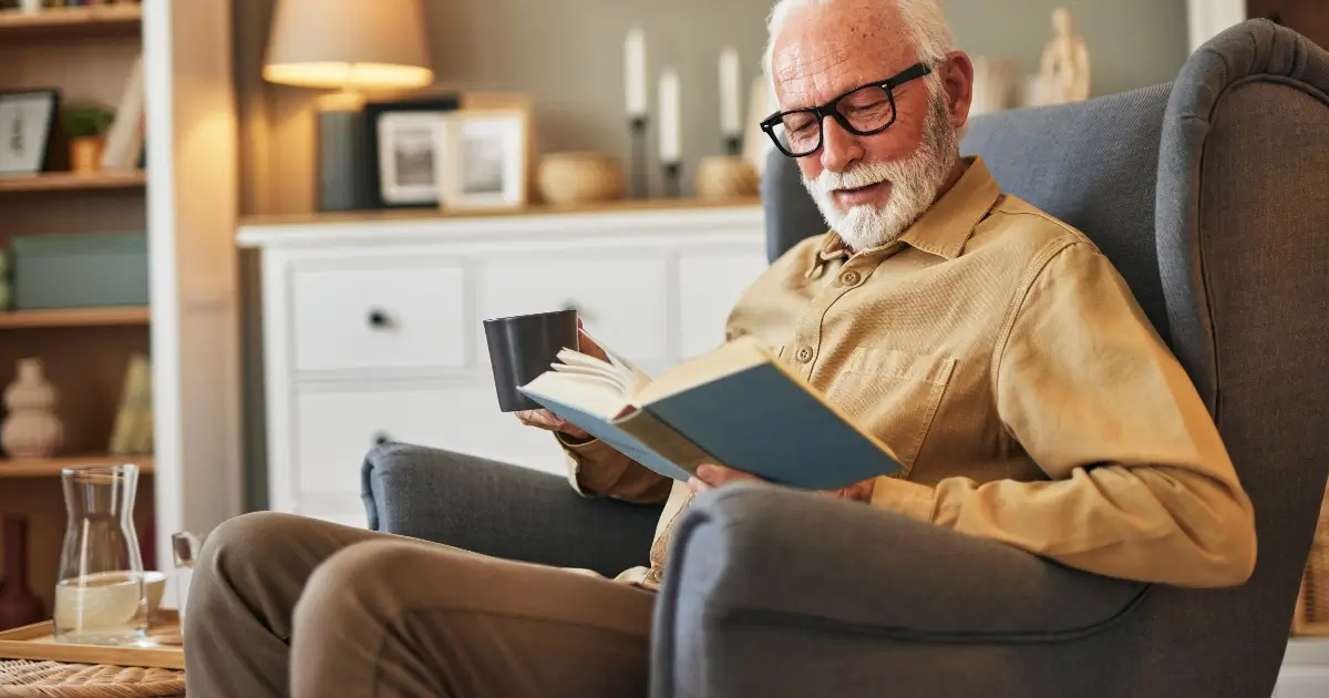 Elderly affluent man reading book at home